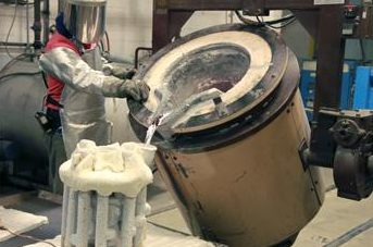 Operator pours melted aluminum during the investment casting process